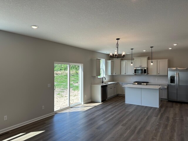 1866 Charleston Ln, Waconia, MN 55387 - kitchen featuring appliances with stainless steel finishes, light countertops, a chandelier, dark wood-type flooring, and a textured ceiling