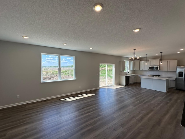 1866 Charleston Ln, Waconia, MN 55387 - unfurnished living room featuring a textured ceiling, recessed lighting, dark wood-style flooring, and a chandelier