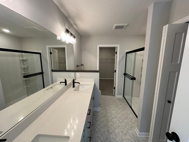1866 Charleston Ln, Waconia, MN 55387 - bathroom with a spacious closet, double vanity, a shower stall, and a textured ceiling
