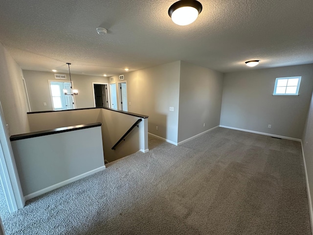 1866 Charleston Ln, Waconia, MN 55387 - unfurnished room with a textured ceiling, a chandelier, healthy amount of natural light, carpet, and a smoke detector