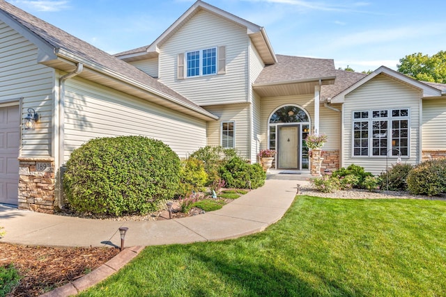 1893 White Oak Dr, Chaska, MN 55318 - view of front of home with a front yard, stone siding, a garage, and roof with shingles