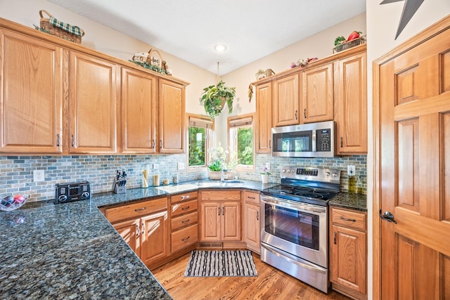 1893 White Oak Dr, Chaska, MN 55318 - kitchen featuring stainless steel appliances, light wood-style floors, dark stone countertops, and tasteful backsplash