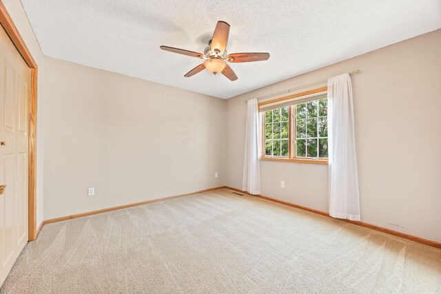 1893 White Oak Dr, Chaska, MN 55318 - unfurnished bedroom with carpet flooring, a textured ceiling, baseboards, and a ceiling fan