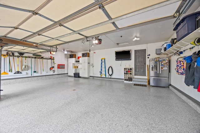 1893 White Oak Dr, Chaska, MN 55318 - garage featuring stainless steel refrigerator with ice dispenser, a garage door opener, baseboards, and freestanding refrigerator