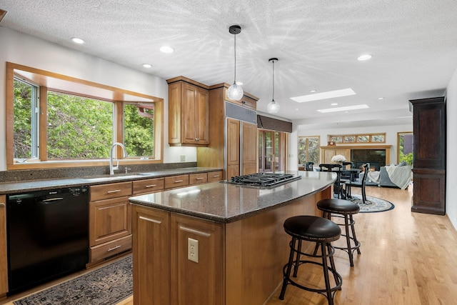 6136 Arctic Way, Edina, MN 55436 - kitchen with dishwasher, stainless steel gas cooktop, a kitchen bar, a kitchen island, and a skylight