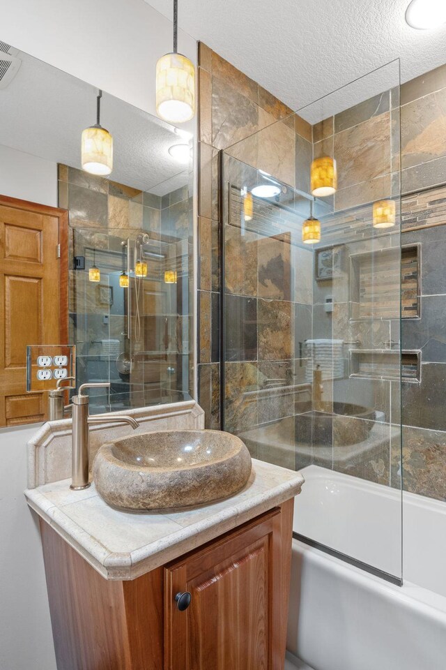 6136 Arctic Way, Edina, MN 55436 - full bath featuring a textured ceiling, vanity, and bath / shower combo with glass door