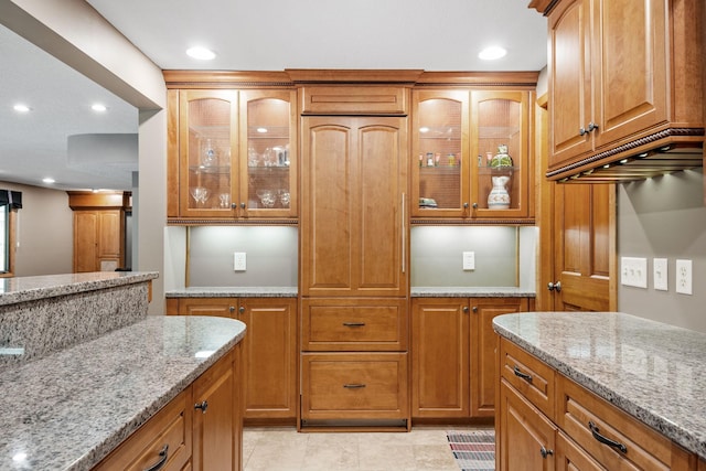 6136 Arctic Way, Edina, MN 55436 - kitchen featuring light stone counters, glass insert cabinets, brown cabinets, recessed lighting, and light tile patterned flooring