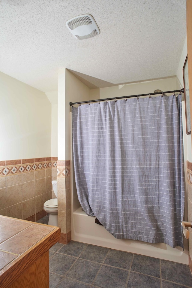 1496 Willard Lake Rd NW, Powers Twp, MN 56435 - bathroom with wainscoting, shower / tub combo with curtain, tile walls, a textured ceiling, and vanity