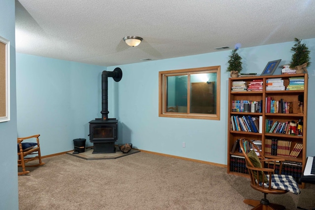 1496 Willard Lake Rd NW, Powers Twp, MN 56435 - sitting room featuring carpet, a wood stove, and a textured ceiling