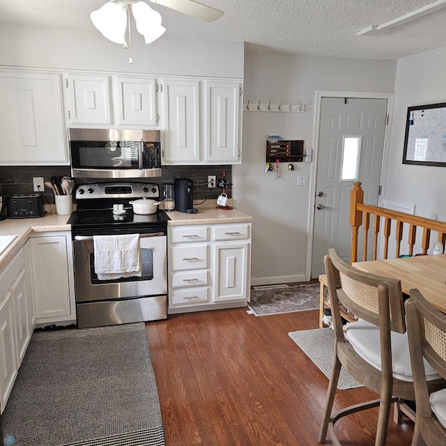 849 11th Ave W, West Fargo, ND 58078 - kitchen featuring stainless steel appliances, light countertops, white cabinets, decorative backsplash, and dark wood finished floors