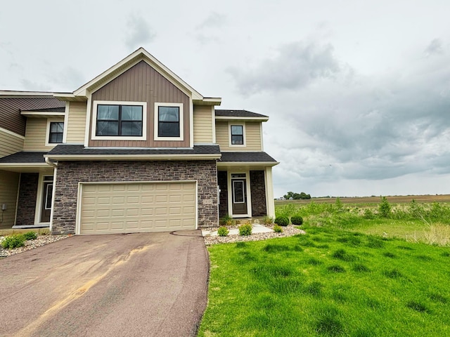 18105 Gavel Ln, Lakeville, MN 55044 - view of front of house with asphalt driveway, an attached garage, a front yard, board and batten siding, and a shingled roof