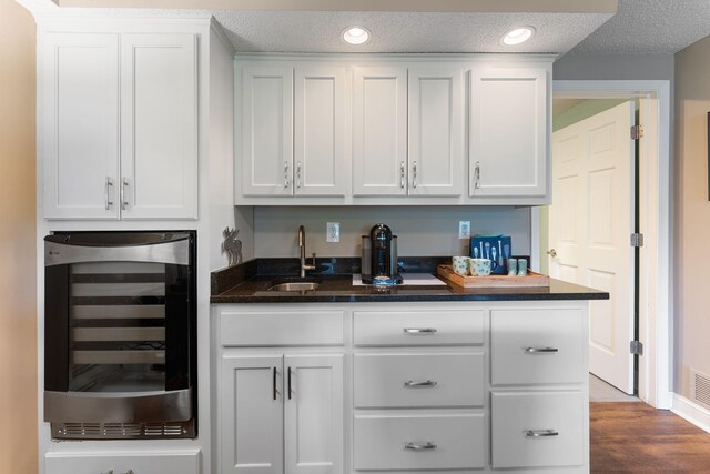 6813 Boudin St NE, Prior Lake, MN 55372 - indoor wet bar featuring wine cooler, dark wood-type flooring, a textured ceiling, and recessed lighting