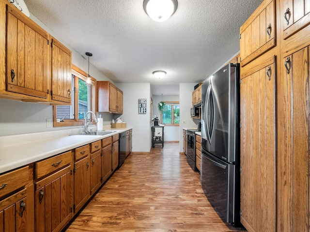 21534 275th Ave, Glenwood Twp, MN 56381 - kitchen with freestanding refrigerator, a sink, range with electric stovetop, light wood-style floors, and a textured ceiling