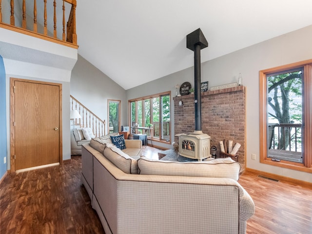21534 275th Ave, Glenwood Twp, MN 56381 - living area featuring a wood stove, wood finished floors, stairs, baseboards, and high vaulted ceiling
