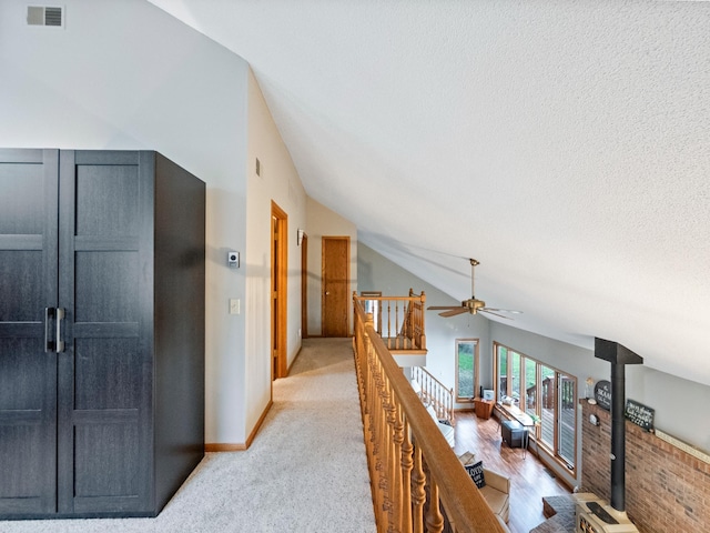 21534 275th Ave, Glenwood Twp, MN 56381 - corridor featuring an upstairs landing, baseboards, vaulted ceiling, and light carpet