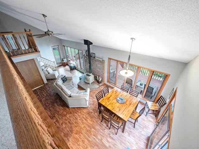 21534 275th Ave, Glenwood Twp, MN 56381 - living area with lofted ceiling, a wood stove, a textured ceiling, wood finished floors, and ceiling fan