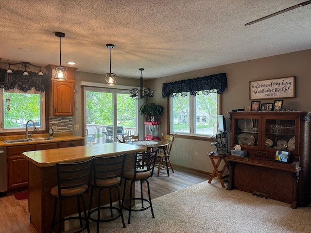802 Estates Ave, Litchfield, MN 55355 - kitchen featuring a sink, light countertops, light wood finished floors, a center island, and a textured ceiling