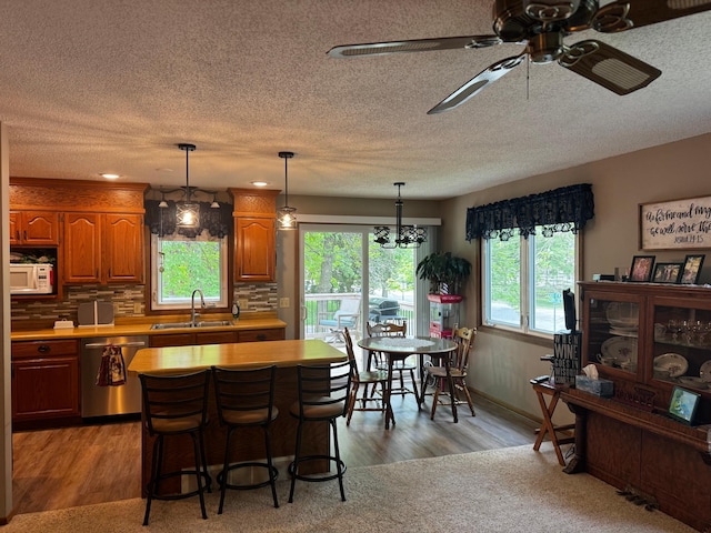 802 Estates Ave, Litchfield, MN 55355 - kitchen featuring dishwasher, white microwave, a ceiling fan, a sink, and light countertops