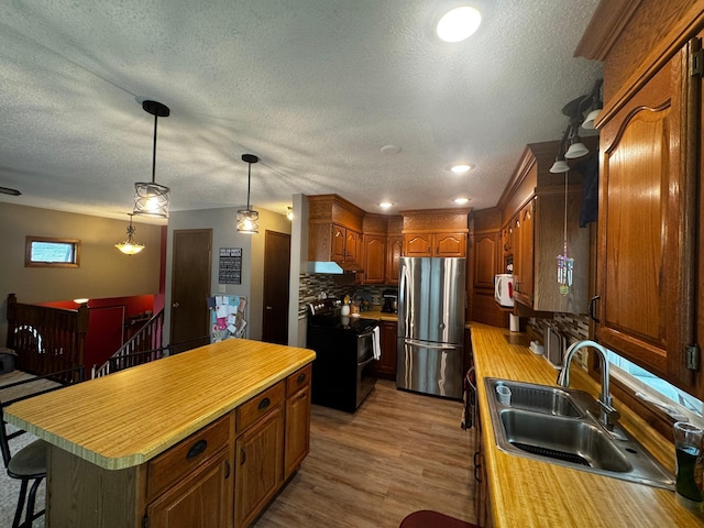 802 Estates Ave, Litchfield, MN 55355 - kitchen with appliances with stainless steel finishes, a sink, a center island, tasteful backsplash, and light countertops