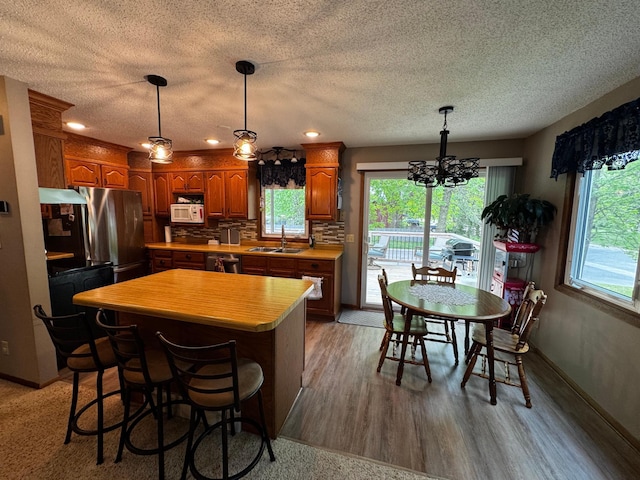802 Estates Ave, Litchfield, MN 55355 - kitchen with appliances with stainless steel finishes, a sink, light countertops, a kitchen island, and a chandelier