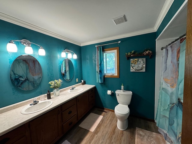 802 Estates Ave, Litchfield, MN 55355 - full bathroom with wood finished floors, double vanity, toilet, crown molding, and baseboards