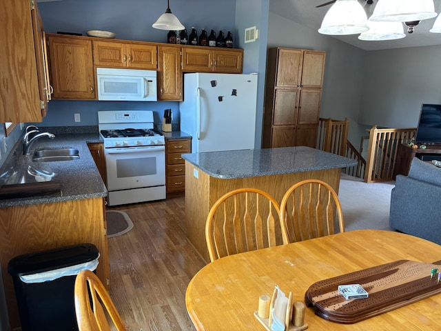 2030 Joes Lake Rd SE, Cambridge, MN 55008 - kitchen featuring white appliances, dark wood-style flooring, a center island, brown cabinetry, and vaulted ceiling