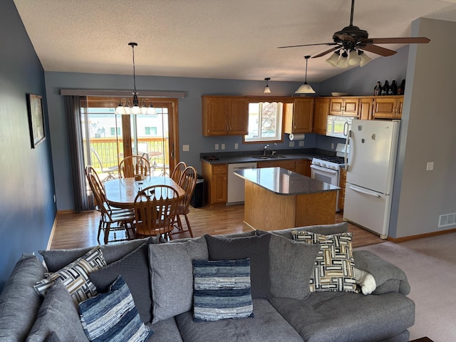 2030 Joes Lake Rd SE, Cambridge, MN 55008 - kitchen with white appliances, open floor plan, vaulted ceiling, dark countertops, and a center island