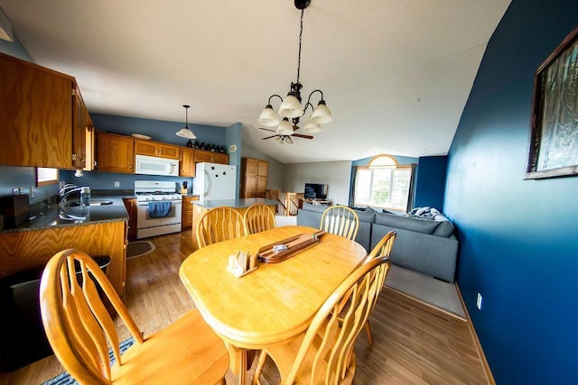 2030 Joes Lake Rd SE, Cambridge, MN 55008 - dining space featuring a chandelier, lofted ceiling, and dark wood-style flooring