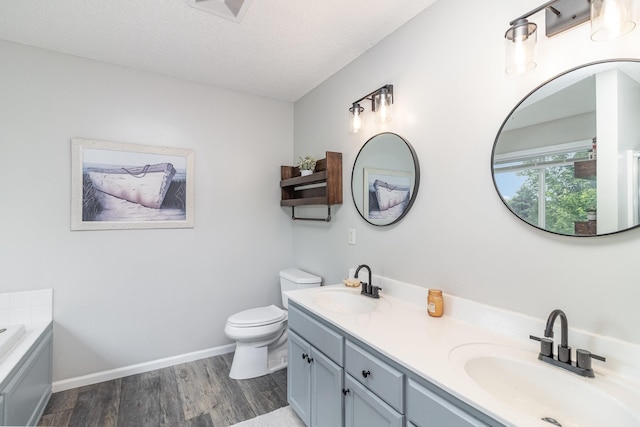26821 Weston Ct, Elko New Market, MN 55020 - full bath featuring double vanity, wood finished floors, a bath, toilet, and a textured ceiling