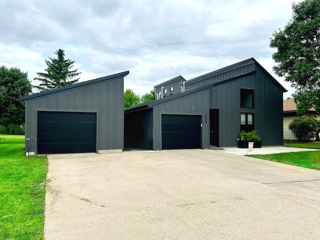 1953 Cecilee St, Worthington, MN 56187 - view of front of house featuring board and batten siding, concrete driveway, and an outbuilding