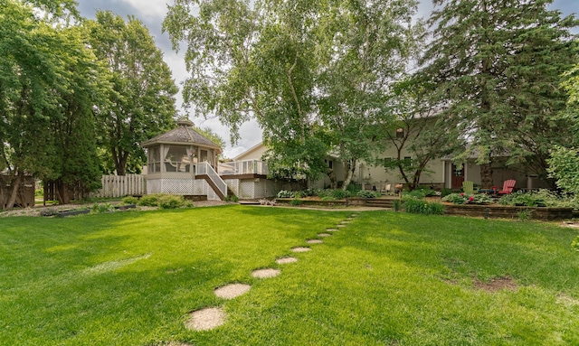 805 5th St NW, Kasson, MN 55944 - view of green lawn with stairway, a sunroom, and a wooden deck