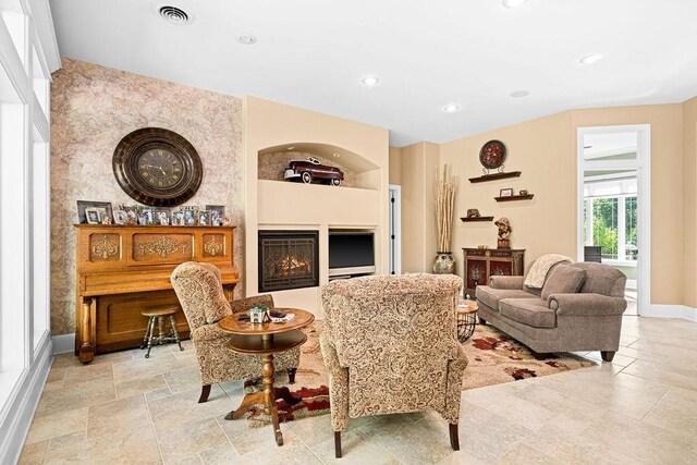 79394 Long Lake Rd, Kettle River Twp, MN 55795 - living room featuring a warm lit fireplace, recessed lighting, baseboards, and light stone finish flooring