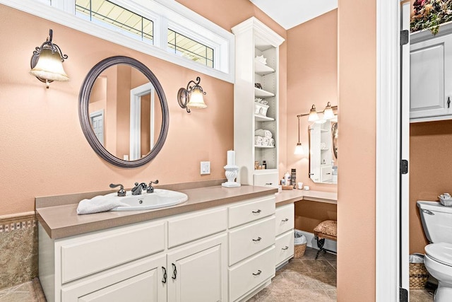 79394 Long Lake Rd, Kettle River Twp, MN 55795 - bathroom with toilet, vanity, built in shelves, and stone finish flooring