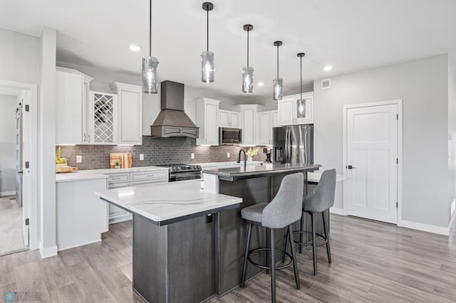 7886 Firefly Ln, Horace, ND 58047 - kitchen with custom range hood, appliances with stainless steel finishes, light wood finished floors, an island with sink, and recessed lighting