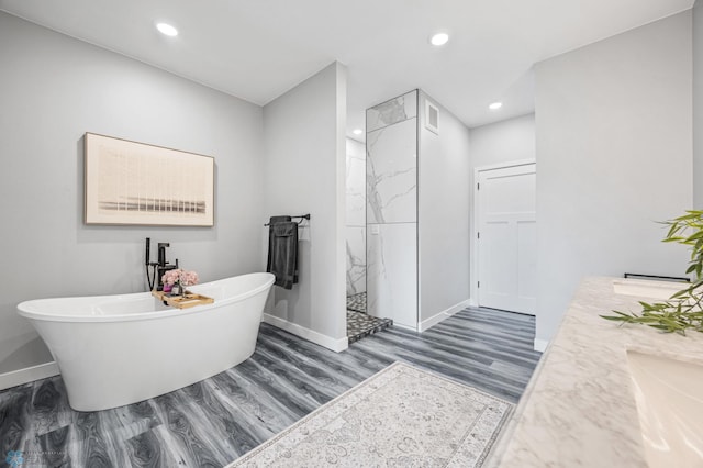 7886 Firefly Ln, Horace, ND 58047 - full bathroom with baseboards, a marble finish shower, wood finished floors, a soaking tub, and recessed lighting