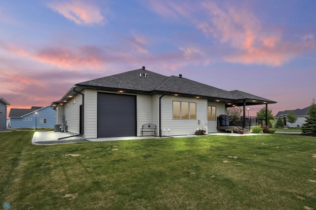 7886 Firefly Ln, Horace, ND 58047 - back of property at dusk with a yard, an attached garage, and roof with shingles