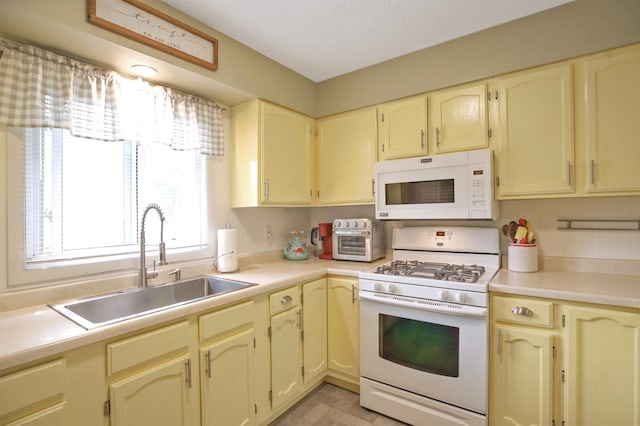 308 18th Ave NE, Waseca, MN 56093 - kitchen featuring white appliances, a sink, cream cabinetry, and light countertops