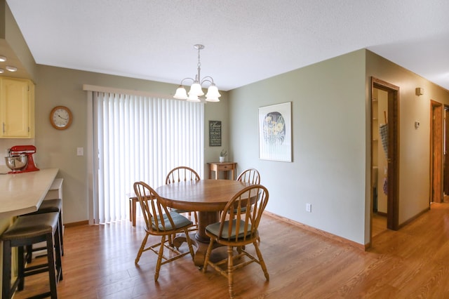 308 18th Ave NE, Waseca, MN 56093 - dining room with a chandelier, light wood finished floors, and baseboards