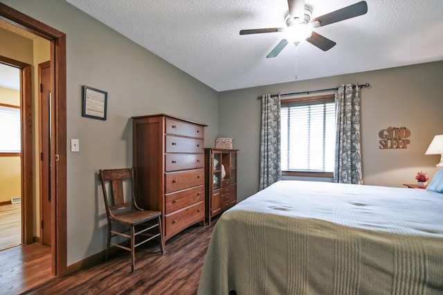308 18th Ave NE, Waseca, MN 56093 - bedroom with dark wood-style flooring, a textured ceiling, baseboards, and a ceiling fan