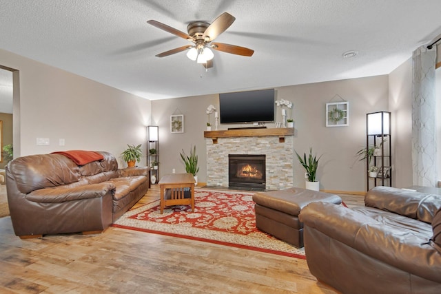 10542 188th Ave NW, Elk River, MN 55330 - living room featuring a ceiling fan, wood finished floors, a stone fireplace, and a textured ceiling