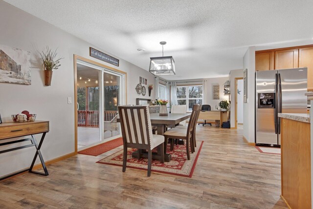 10542 188th Ave NW, Elk River, MN 55330 - dining area featuring light wood-style floors, baseboards, and a textured ceiling