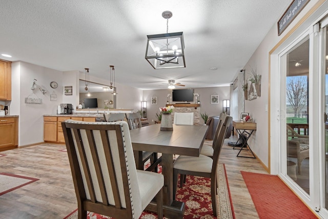 10542 188th Ave NW, Elk River, MN 55330 - dining space with light wood-style floors, ceiling fan, baseboards, a chandelier, and a textured ceiling