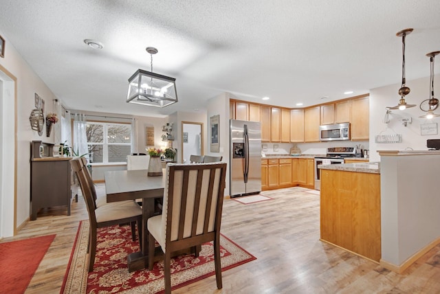 10542 188th Ave NW, Elk River, MN 55330 - dining room with light wood-style floors, a chandelier, a textured ceiling, recessed lighting, and baseboards