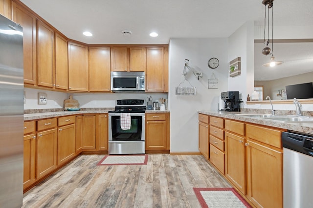 10542 188th Ave NW, Elk River, MN 55330 - kitchen with appliances with stainless steel finishes, a sink, light wood-style floors, hanging light fixtures, and recessed lighting