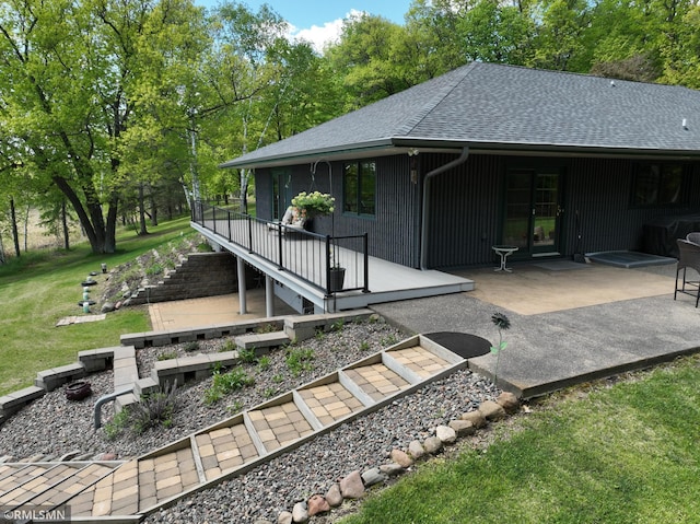 3004 370th Ave, Sandstone, MN 55072 - rear view of house with a shingled roof, a lawn, a deck, a patio, and stairway