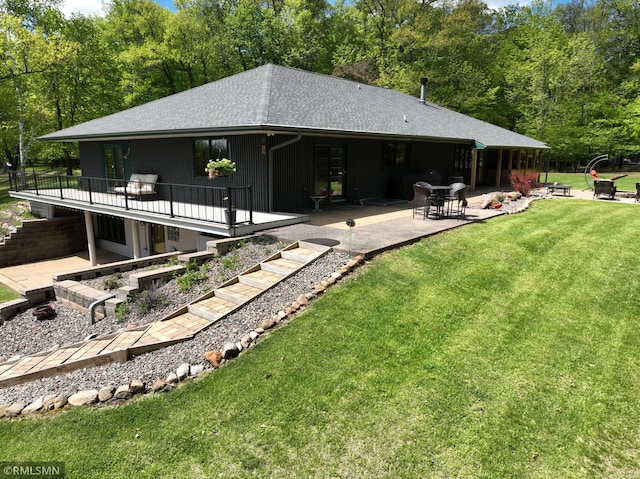 3004 370th Ave, Sandstone, MN 55072 - back of house featuring a patio, a lawn, stairway, a wooden deck, and a shingled roof