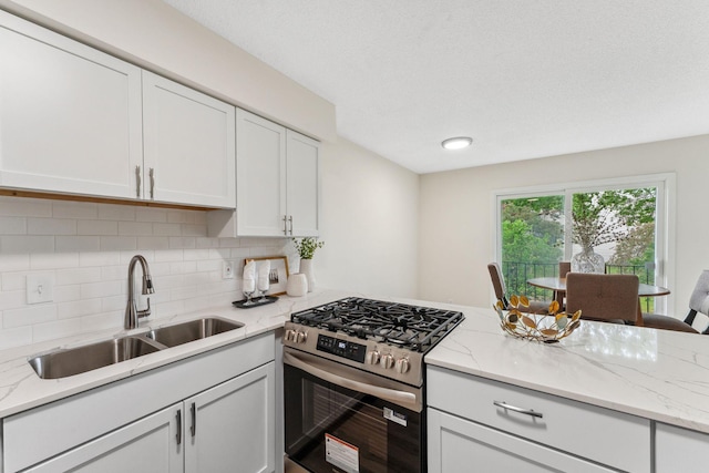 5707 80th Ave N, Brooklyn Park, MN 55443 - kitchen featuring stainless steel gas range oven, a sink, tasteful backsplash, and white cabinetry