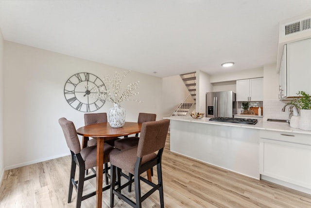 5707 80th Ave N, Brooklyn Park, MN 55443 - dining area featuring light wood-style floors, stairs, and baseboards