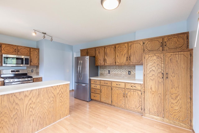 9309 Loch Lomond Ln, Brooklyn Park, MN 55443 - kitchen with appliances with stainless steel finishes, backsplash, light countertops, light wood-style floors, and brown cabinets