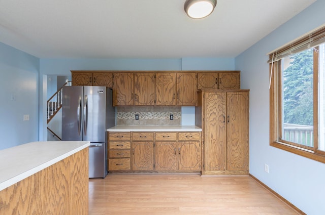 9309 Loch Lomond Ln, Brooklyn Park, MN 55443 - kitchen featuring freestanding refrigerator, light wood finished floors, light countertops, and brown cabinetry
